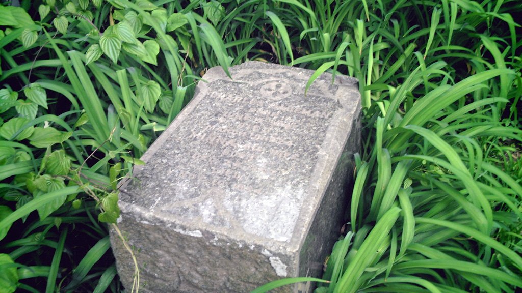Old headstone in the grass at Bachelor's Grove Cemetery